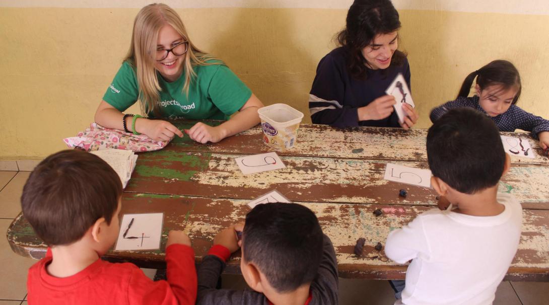 While volunteering abroad as a family, granddaughter and grandmother helped caregivers in Mexico. Swiss volunteer Laurane helping to teach the numbers to little children.